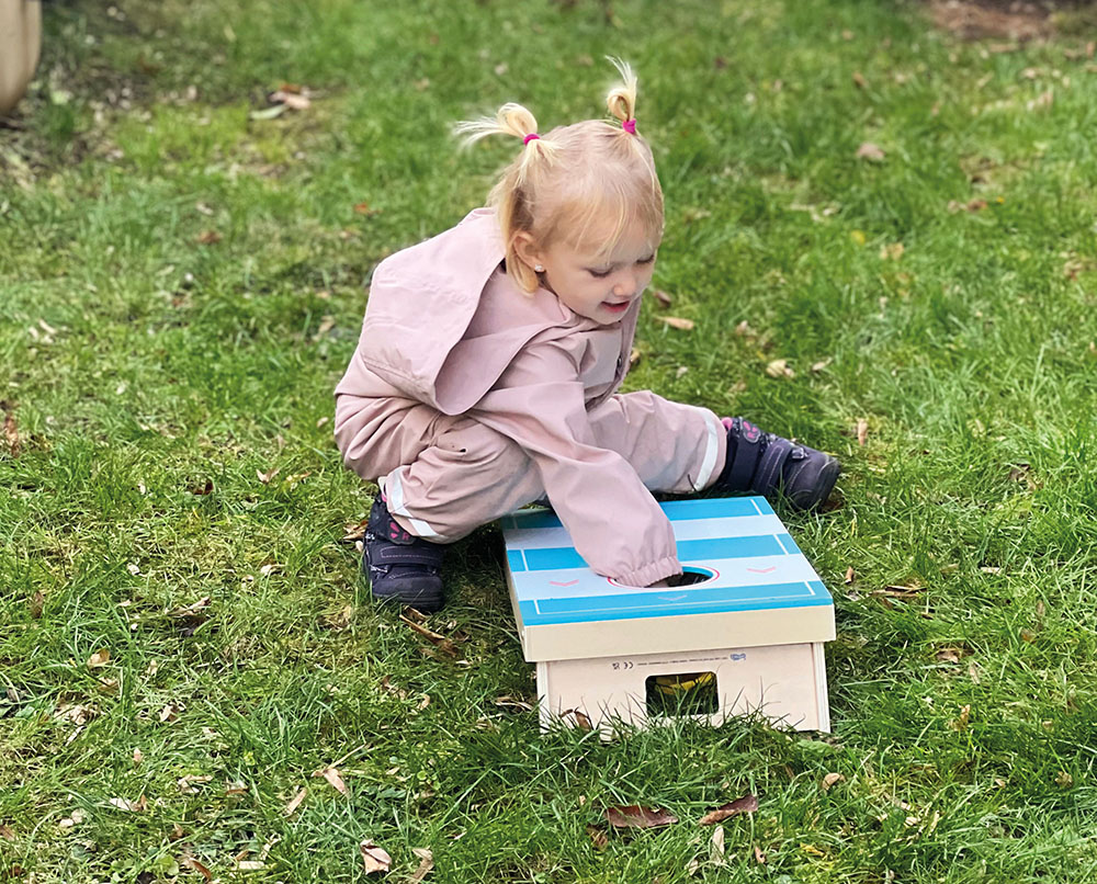 Kinder spielen Cornhole und Sling Puck