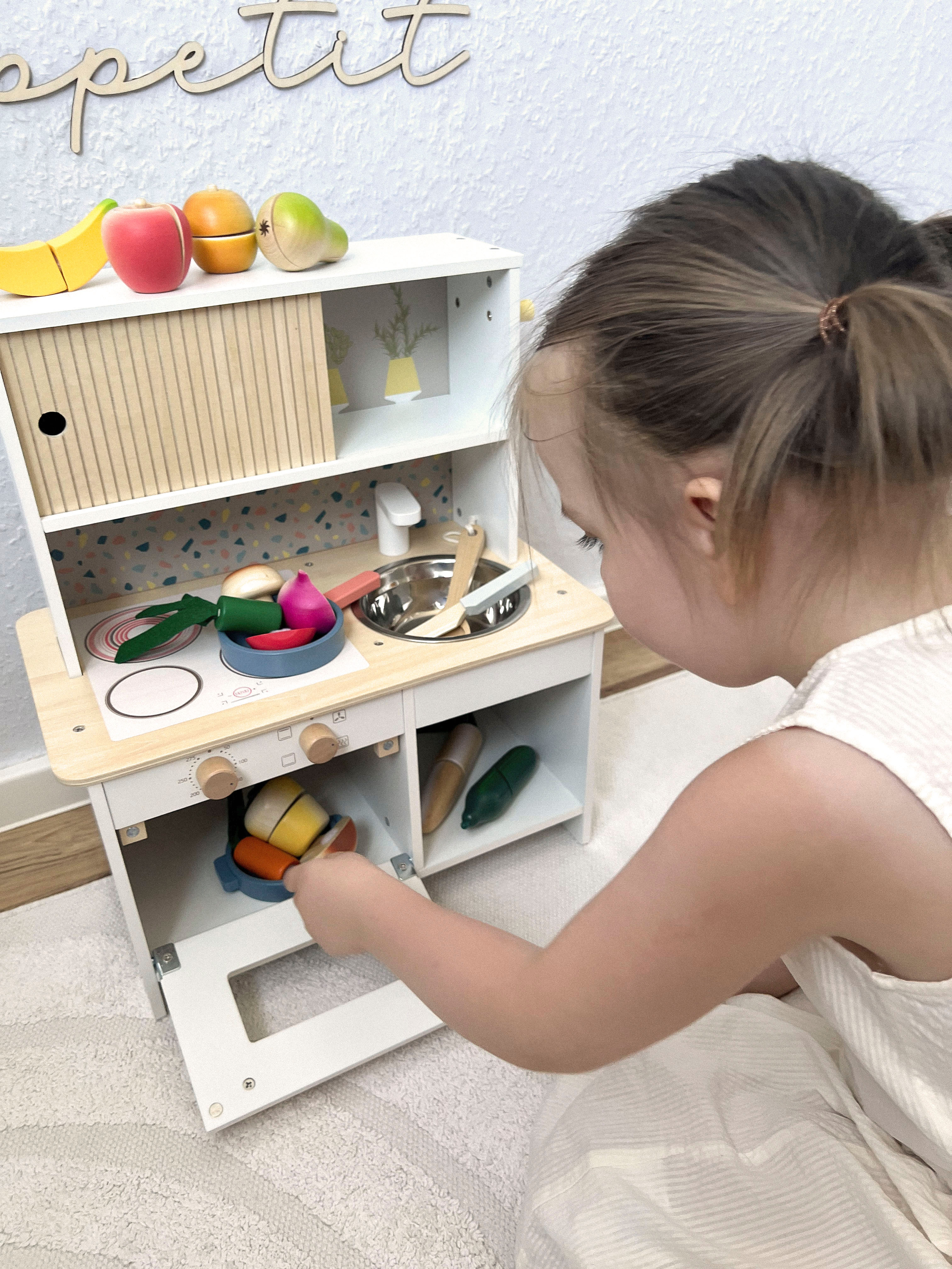 Kind spielt mit Kinderküche Terrazzo kompakt