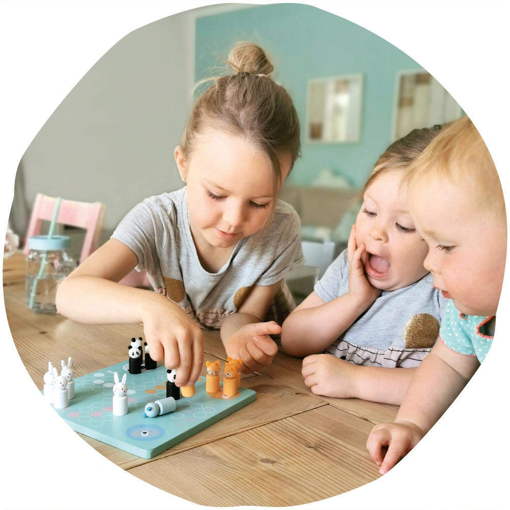 Drei Kinder spielen Ludo aus Holz