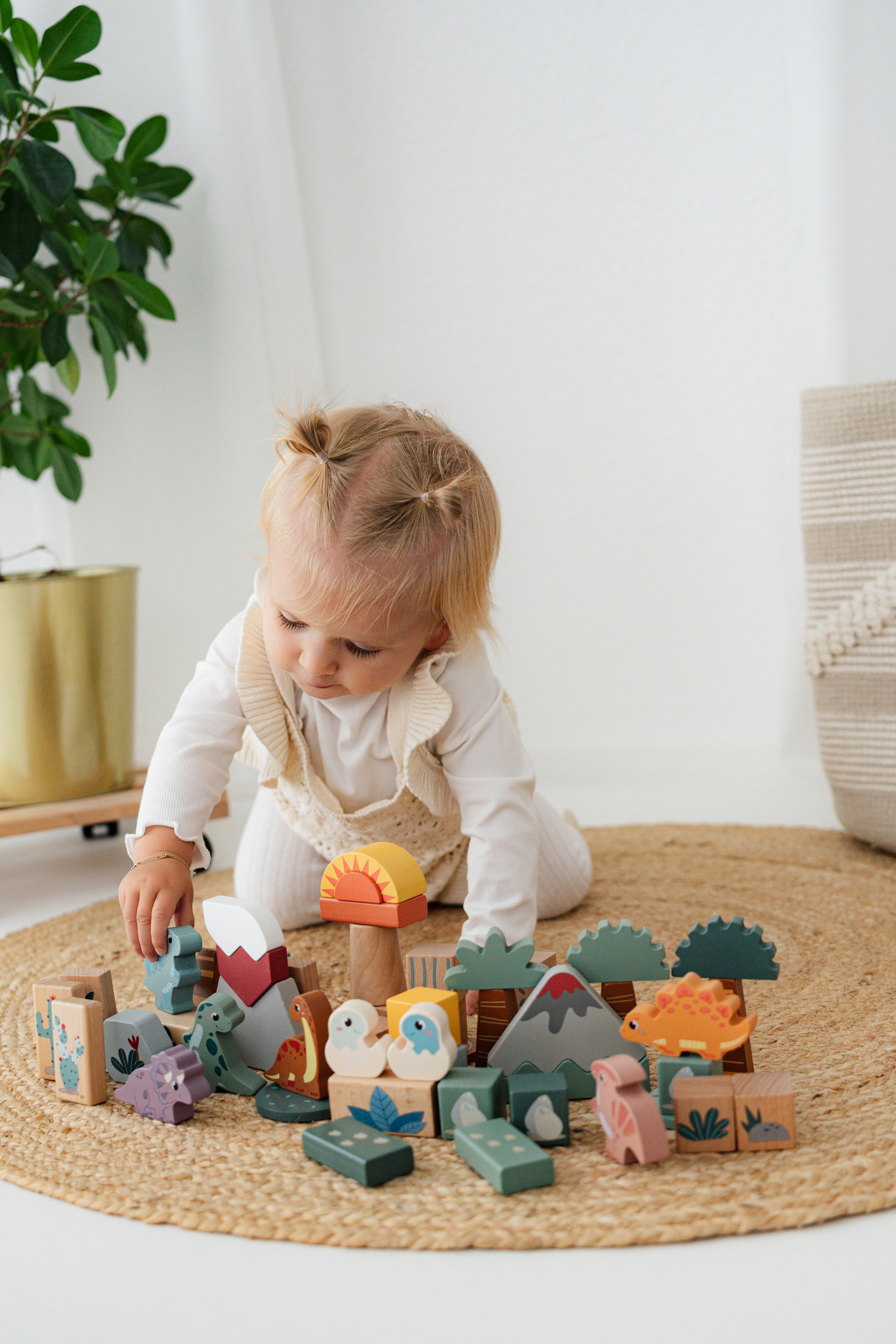 Kind spielt mit Holzbausteine Dino