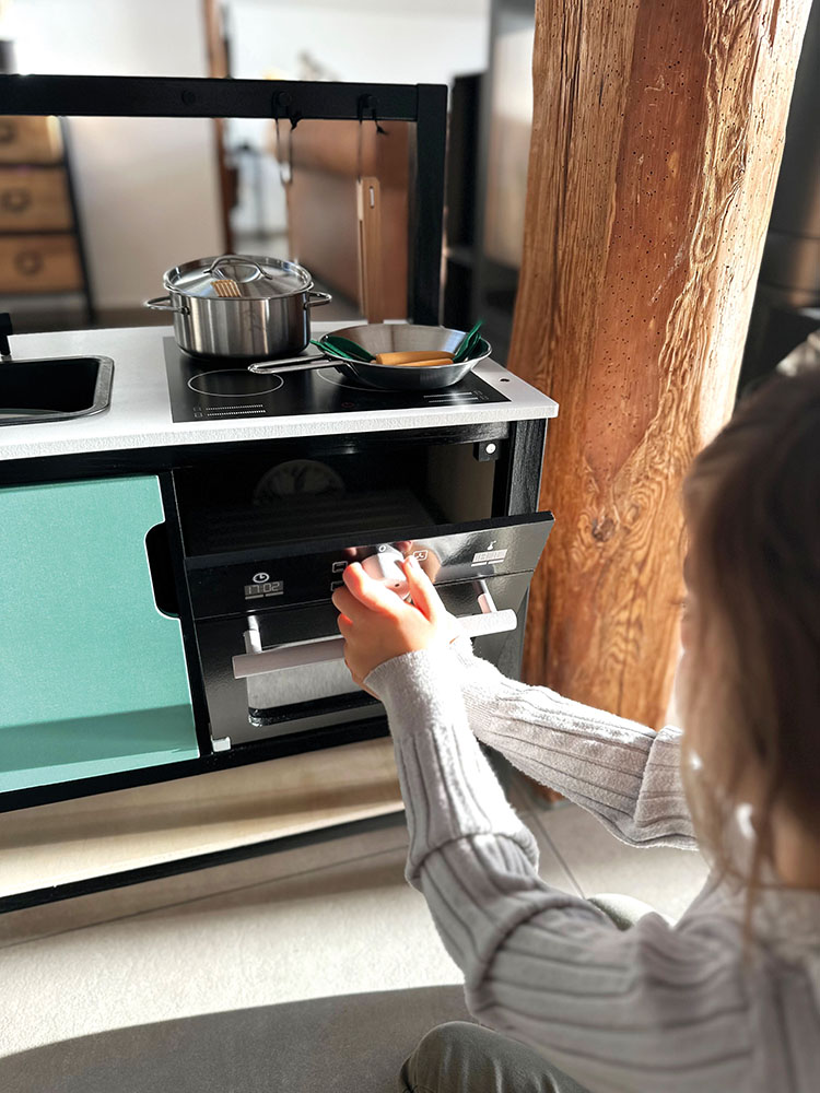 Kind spielt mit Kinderküche Industrial