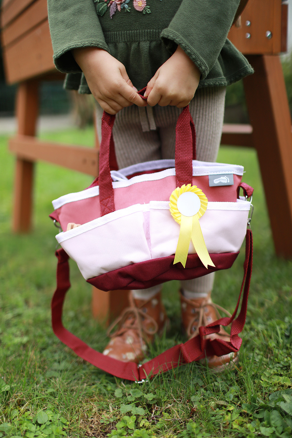 Kind spielt mit Pferdepflegeset mit Tasche rot