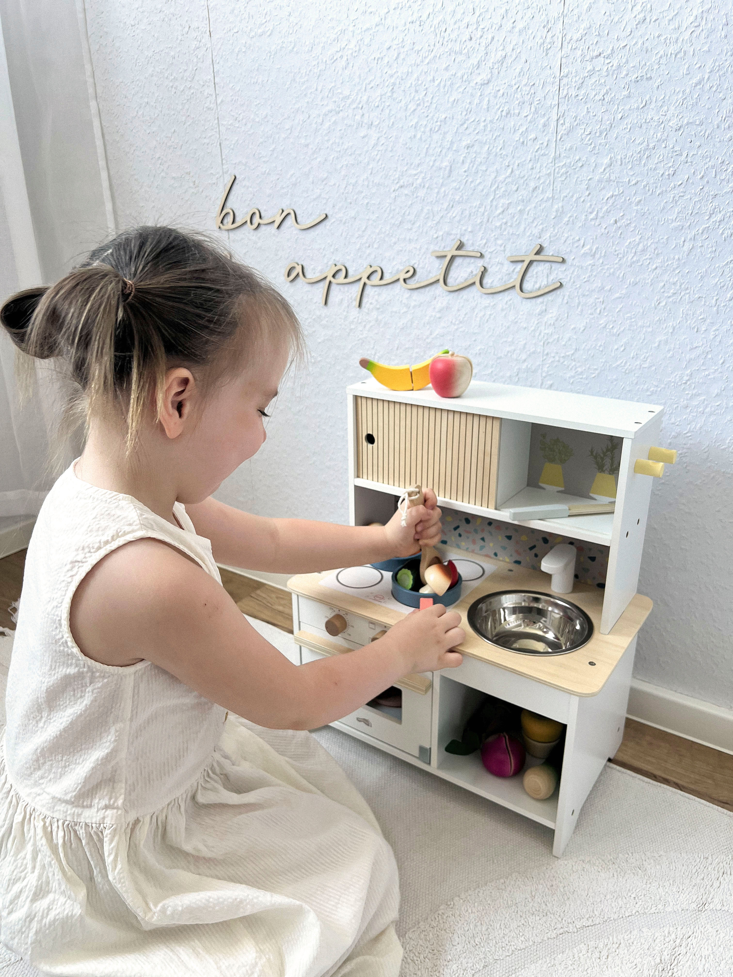 Kind spielt mit Kinderküche Terrazzo kompakt