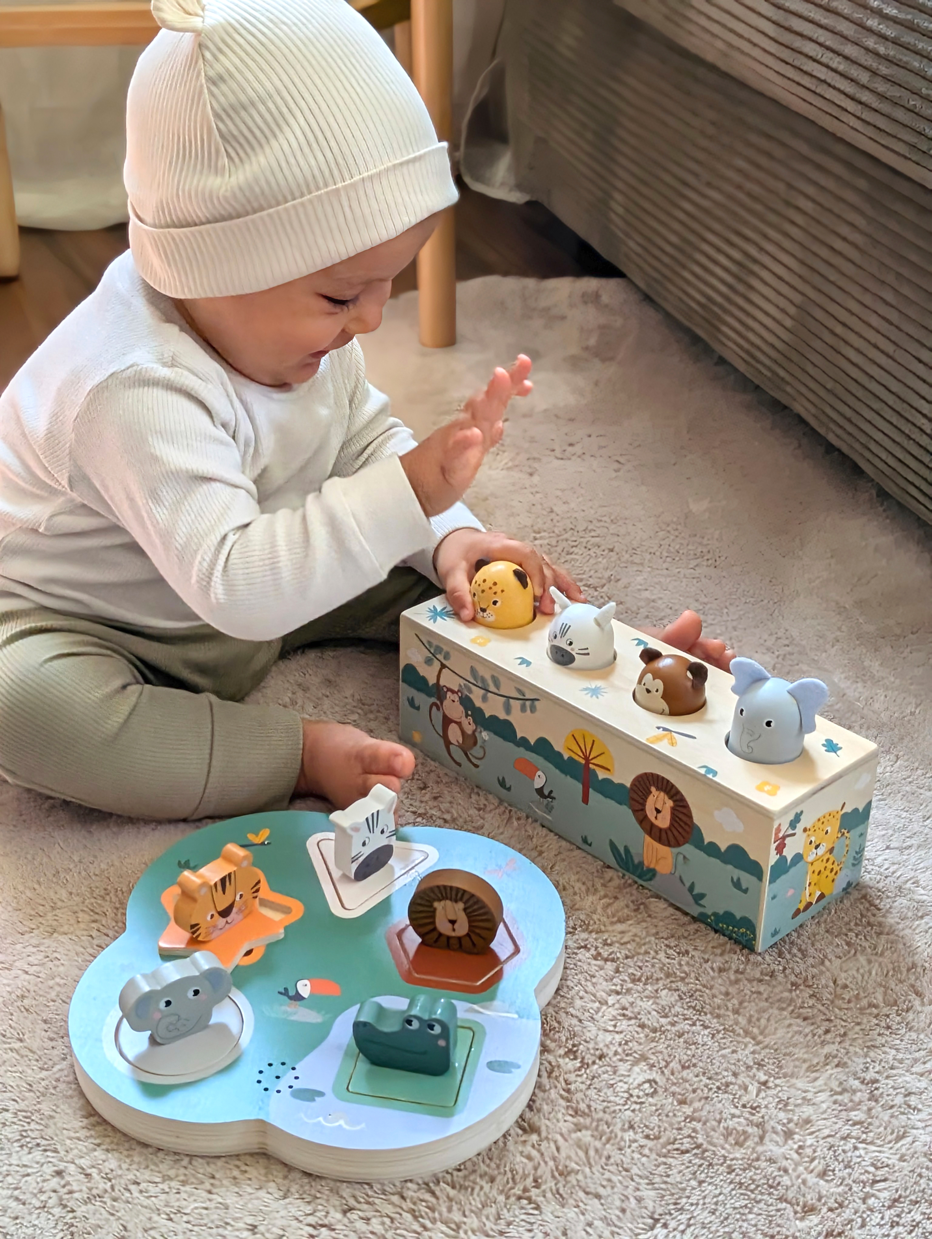 Kind spielt mit Drückspiel Tierlaute Safari