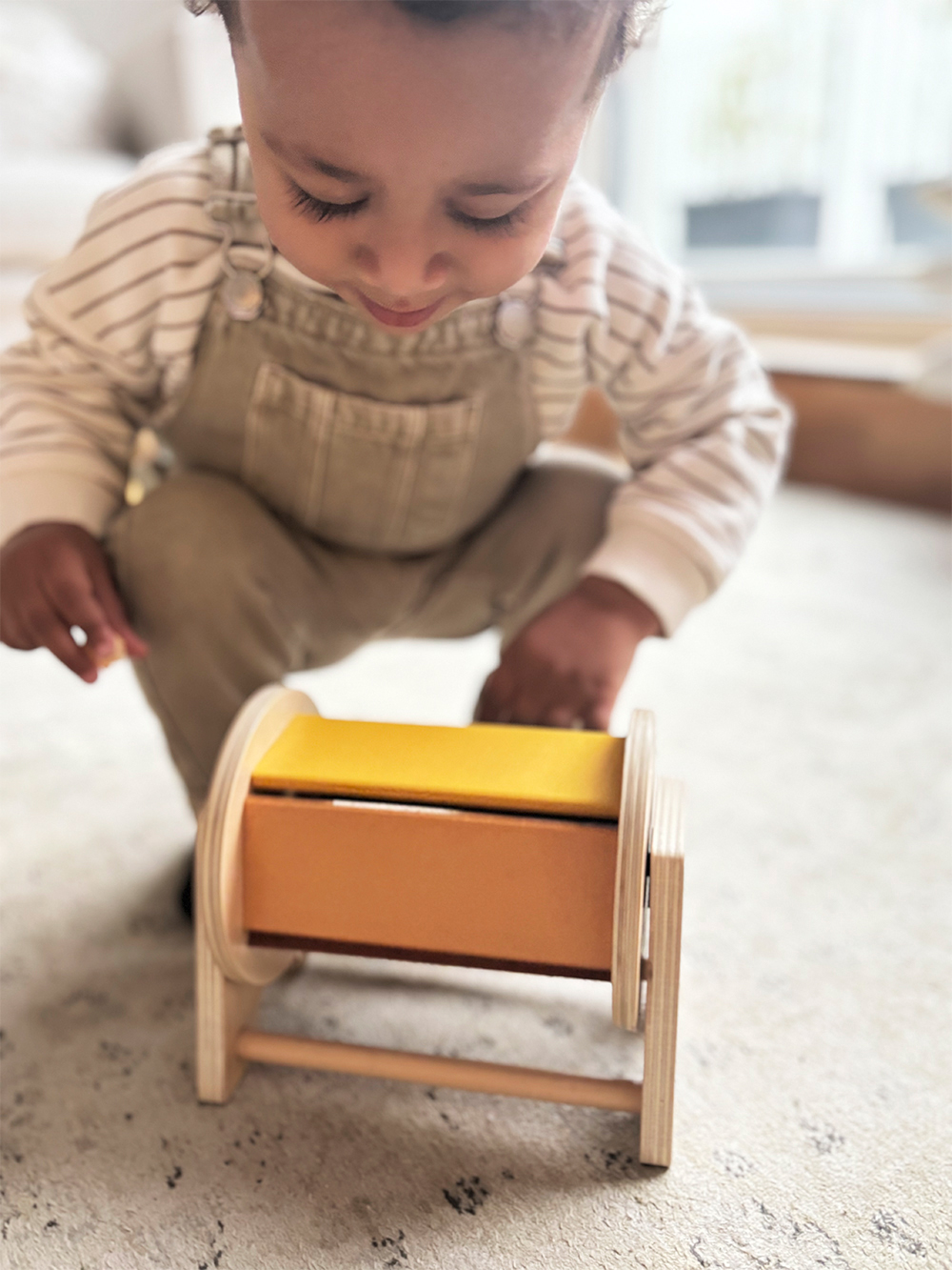 Kind spielt mit Montessori Drehtrommel