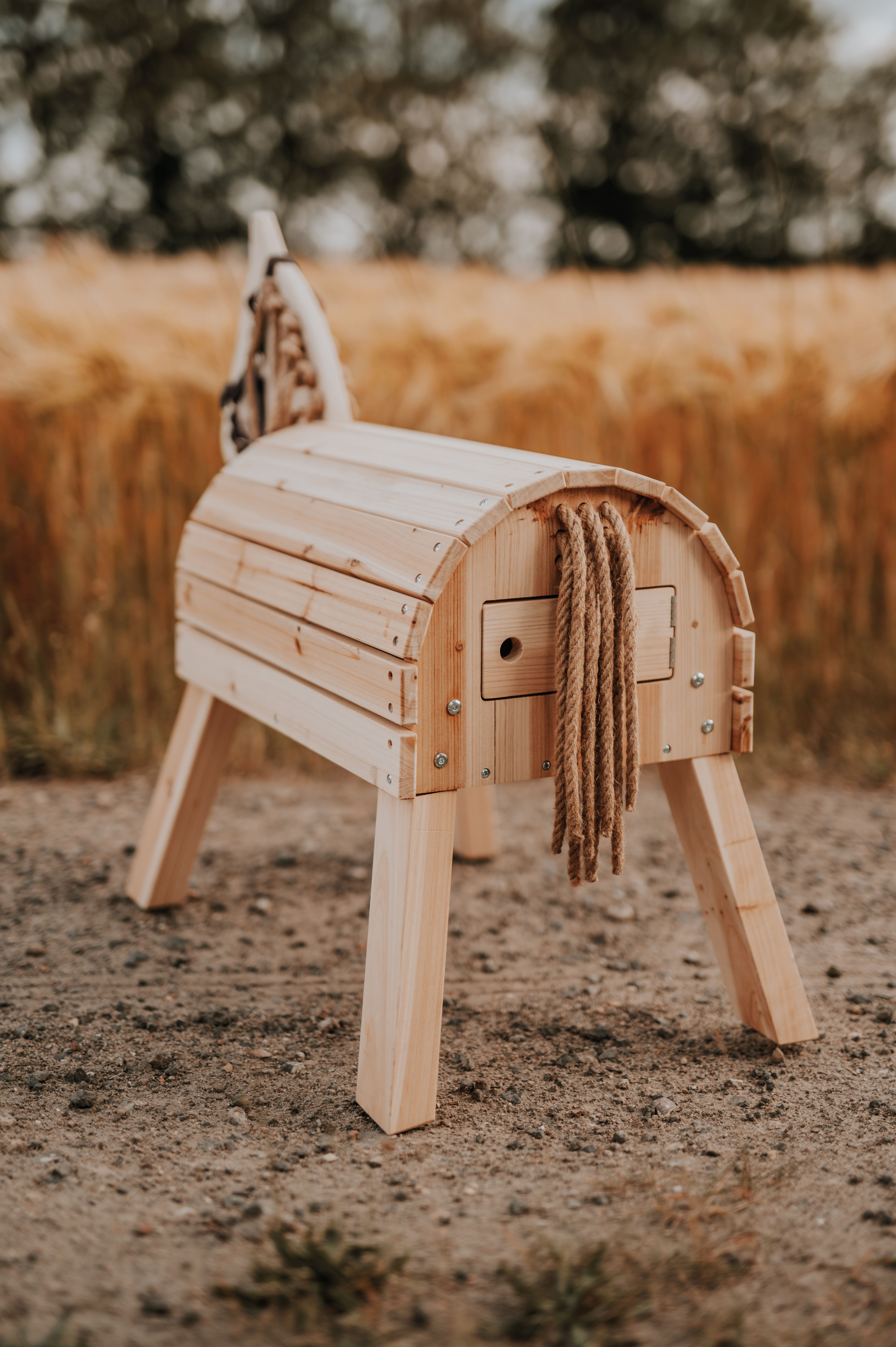 Holzpferd zum Reiten steht auf Feldweg