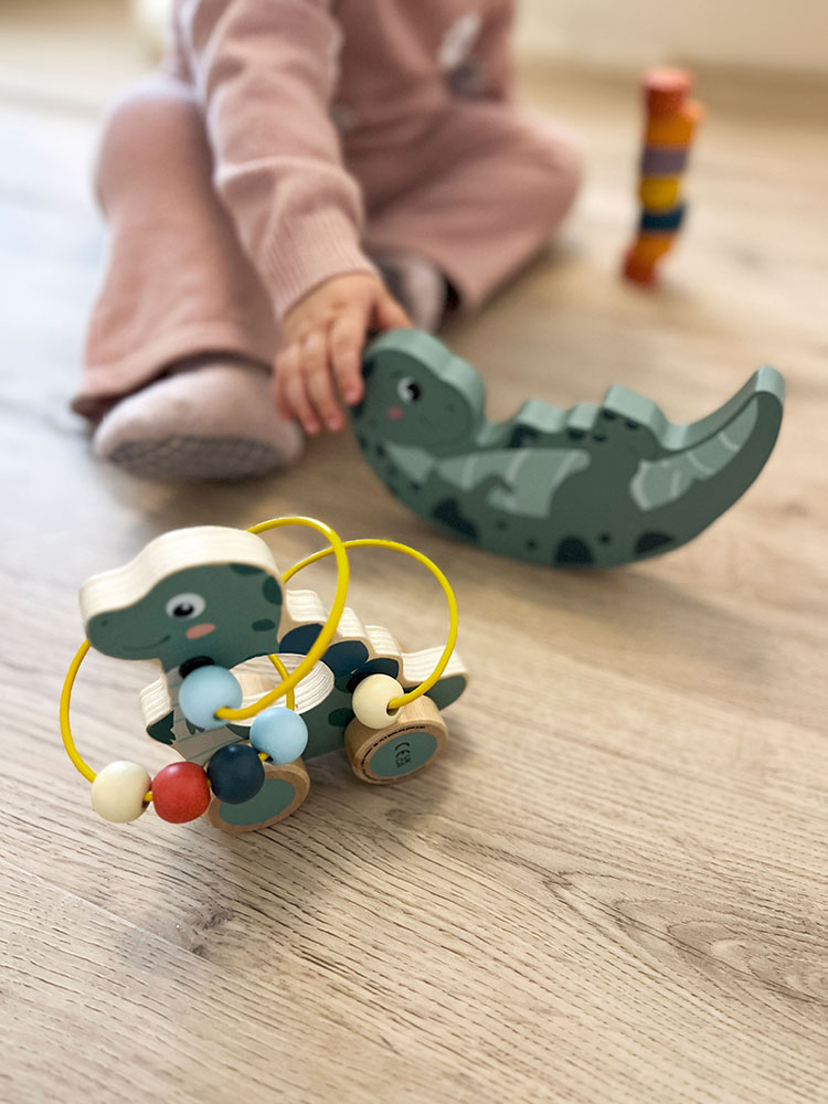 Kind spielt mit Balancierwippe Dinosaurier