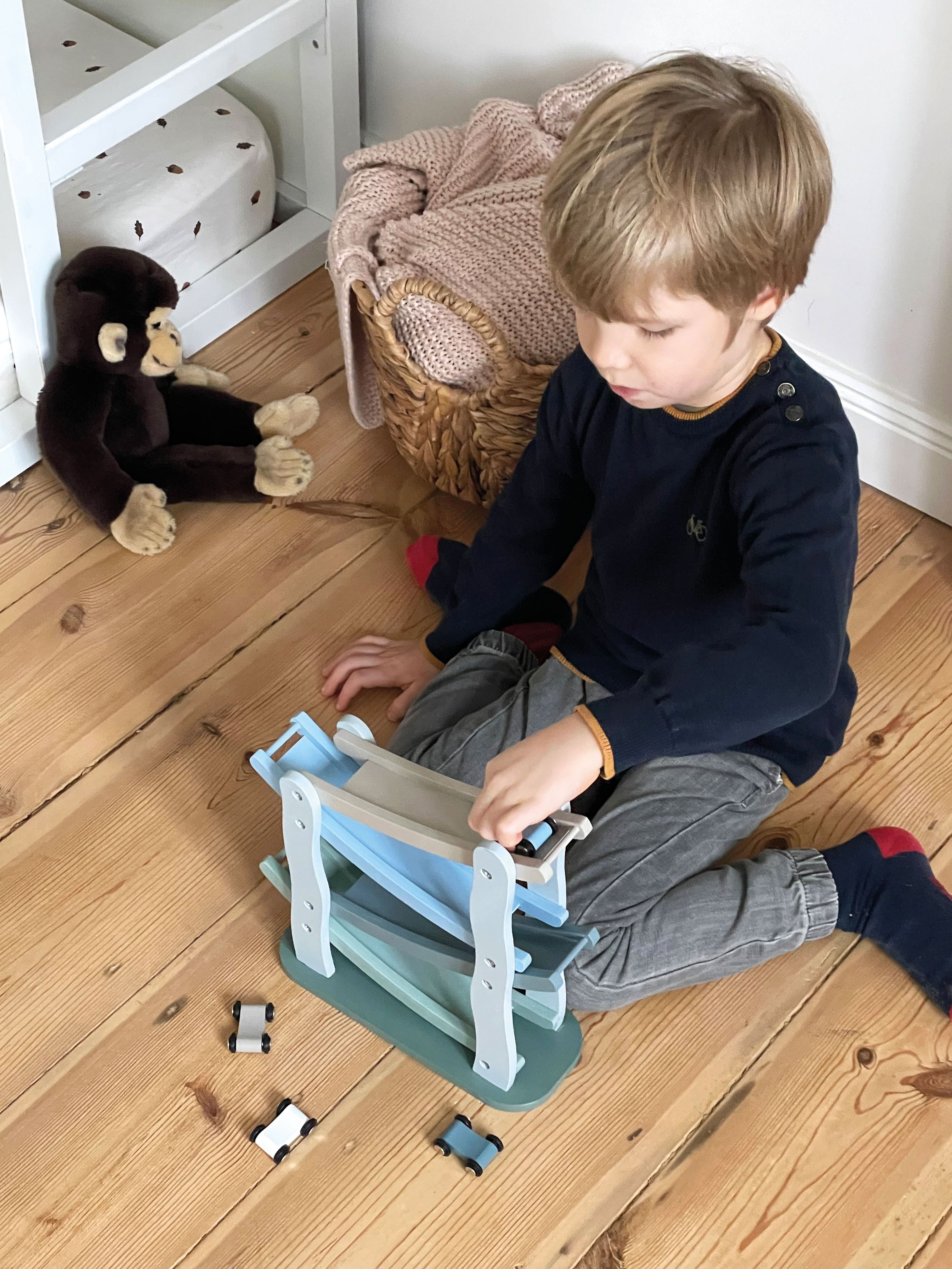 Junge spielt mit Autorennbahn