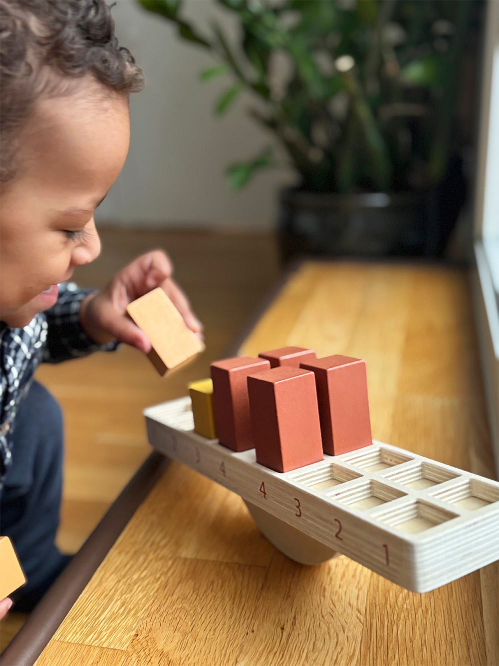 Kind spielt mit Montessori Balancierspiel