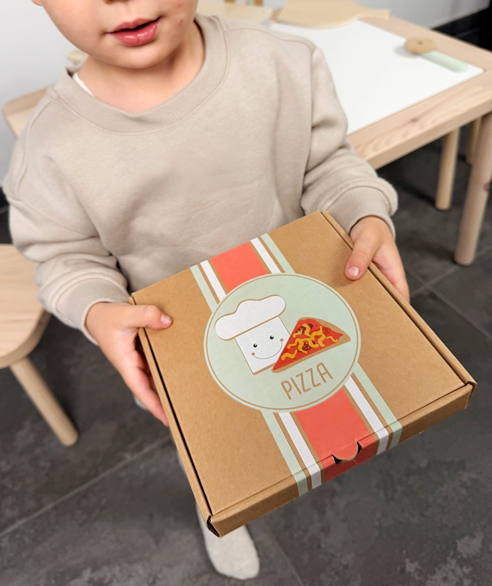 Kind spielt mit Pizza Set mit Ofen