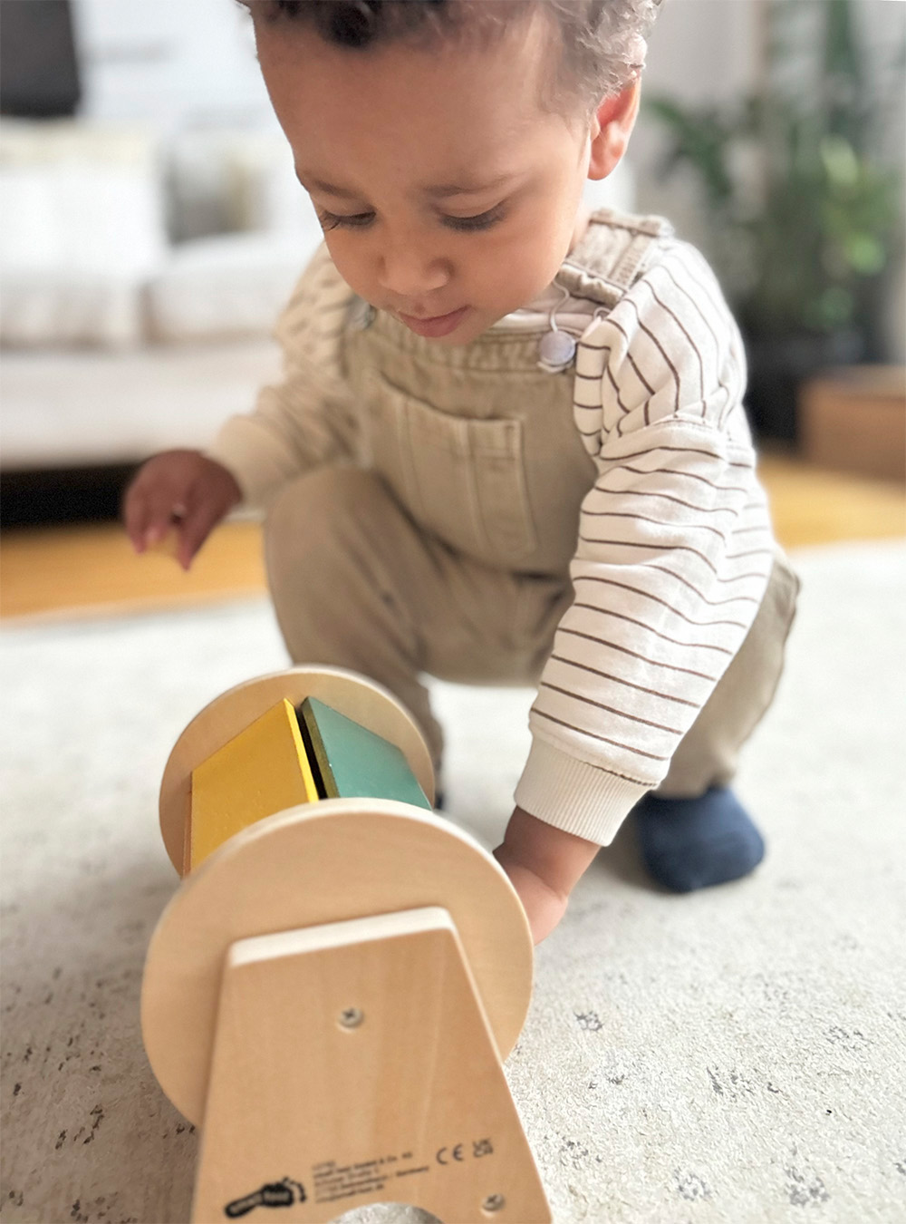 Kind spielt mit Montessori Drehtrommel