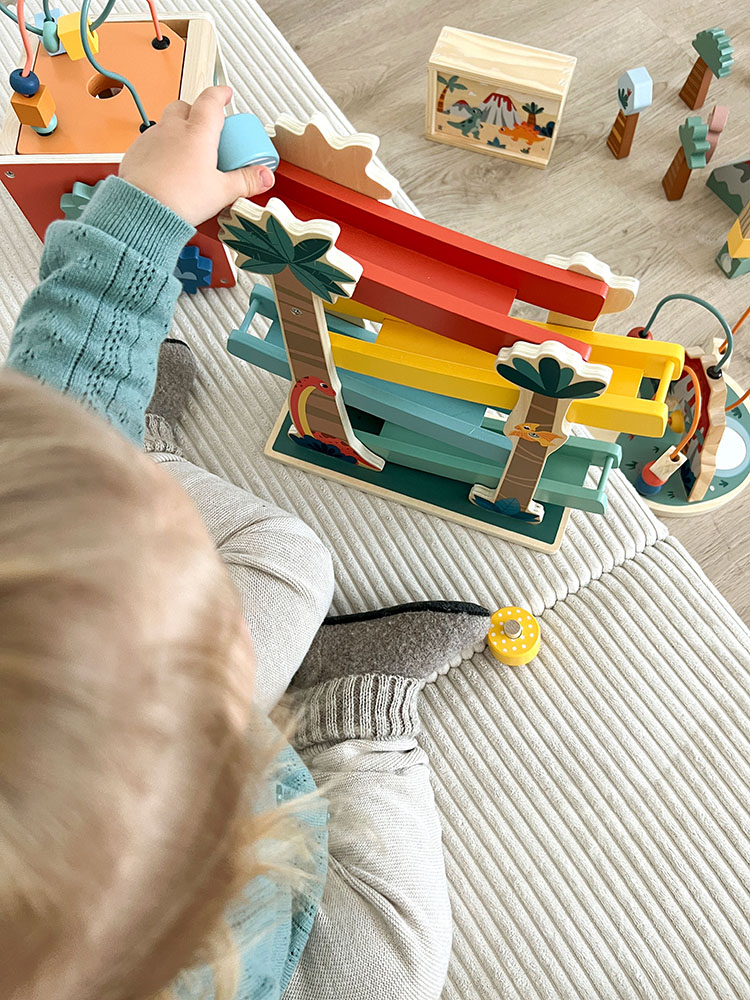 Kind spielt mit Motorikwürfel Dino
