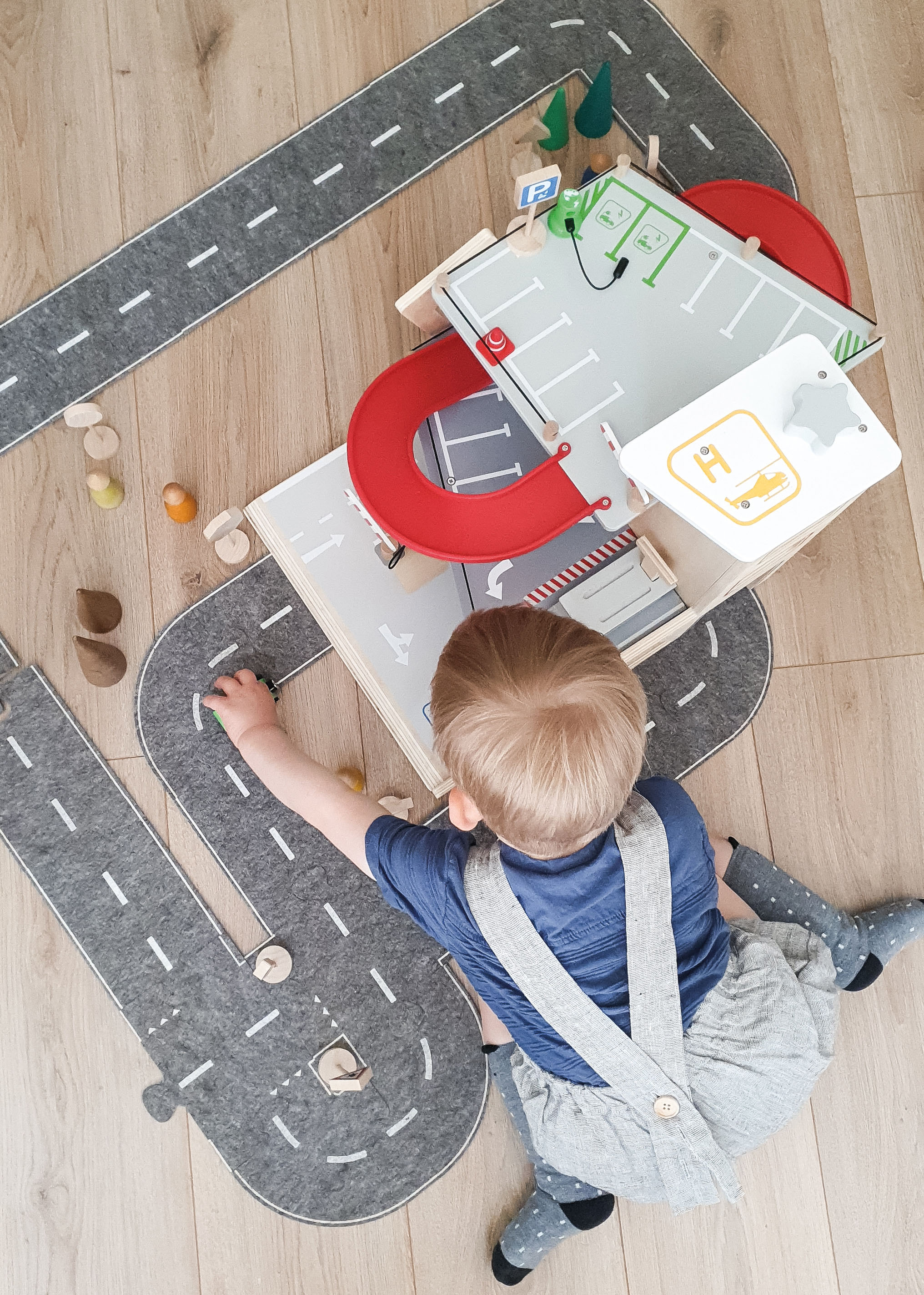 Kind spielt mit großem Parkhaus aus Holz