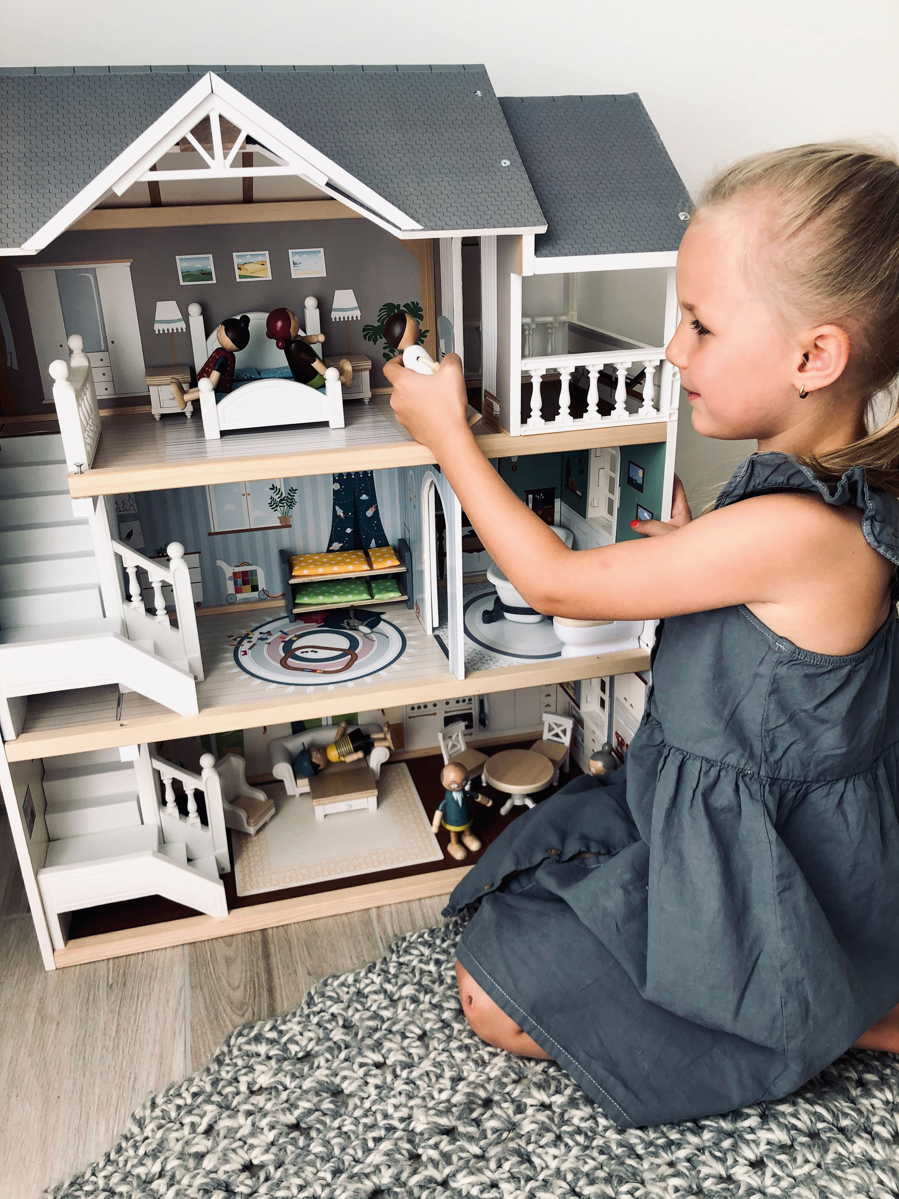 Mädchen mit modernem Holz-Puppenhaus