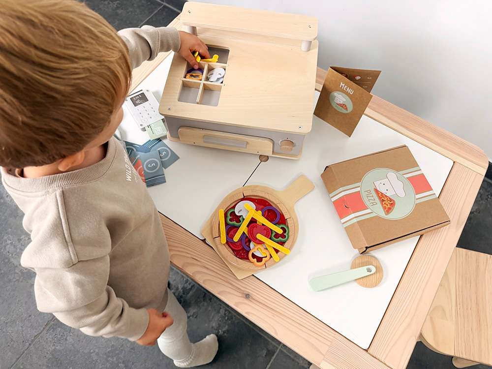 Kind spielt mit Pizza Set mit Ofen
