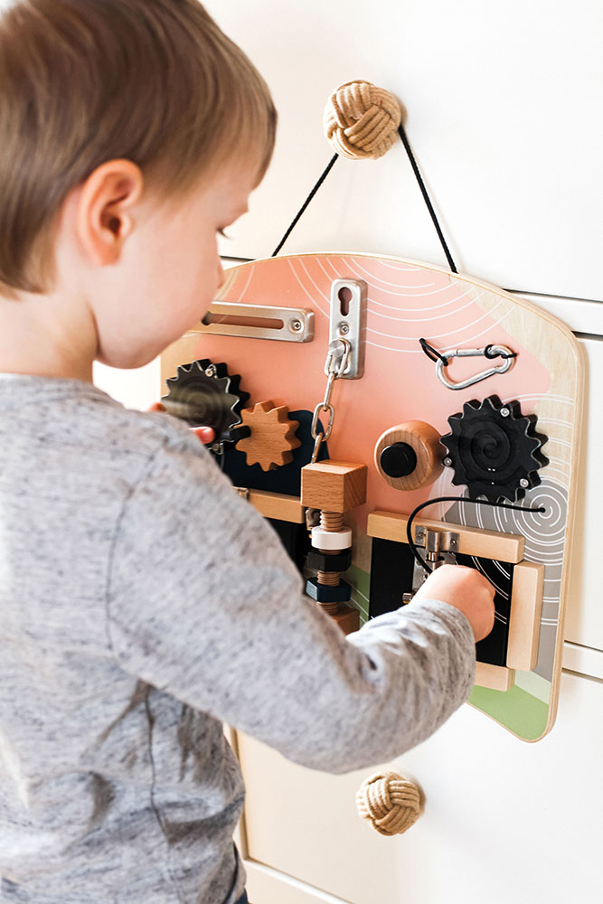 Motorikbrett mit Schlössern Kinderhand bewegt