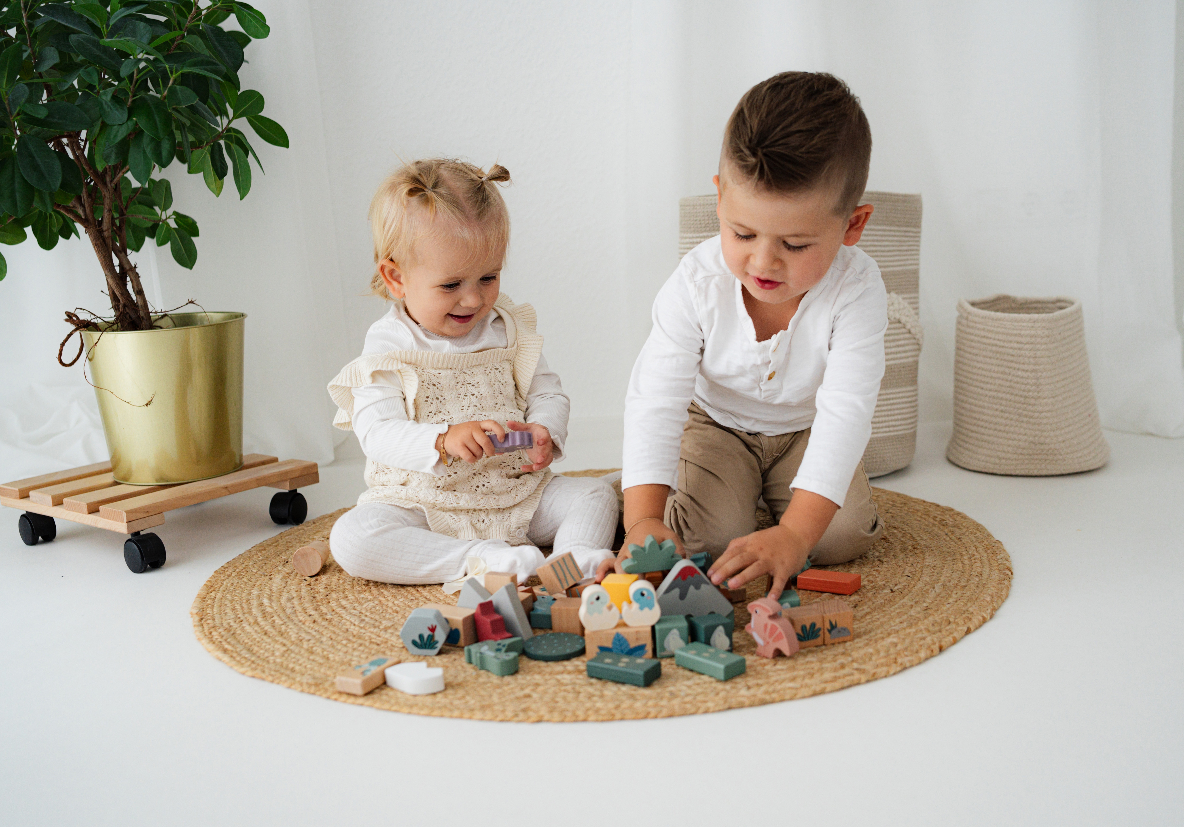 Kind spielt mit Holzbausteine Dino
