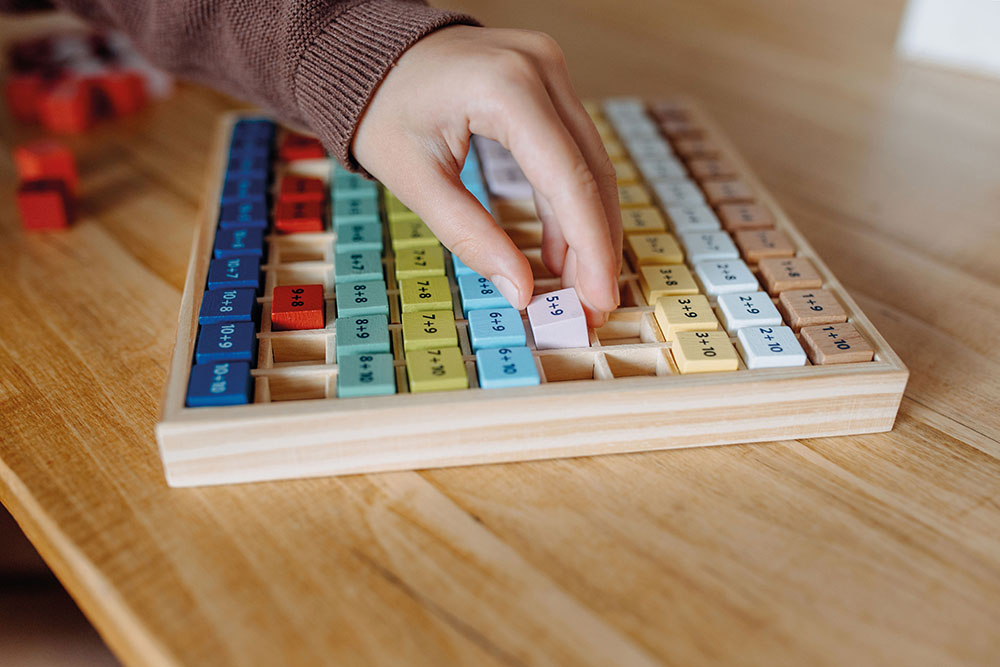 Kind spielt mit Rechenbrett Addition Educate