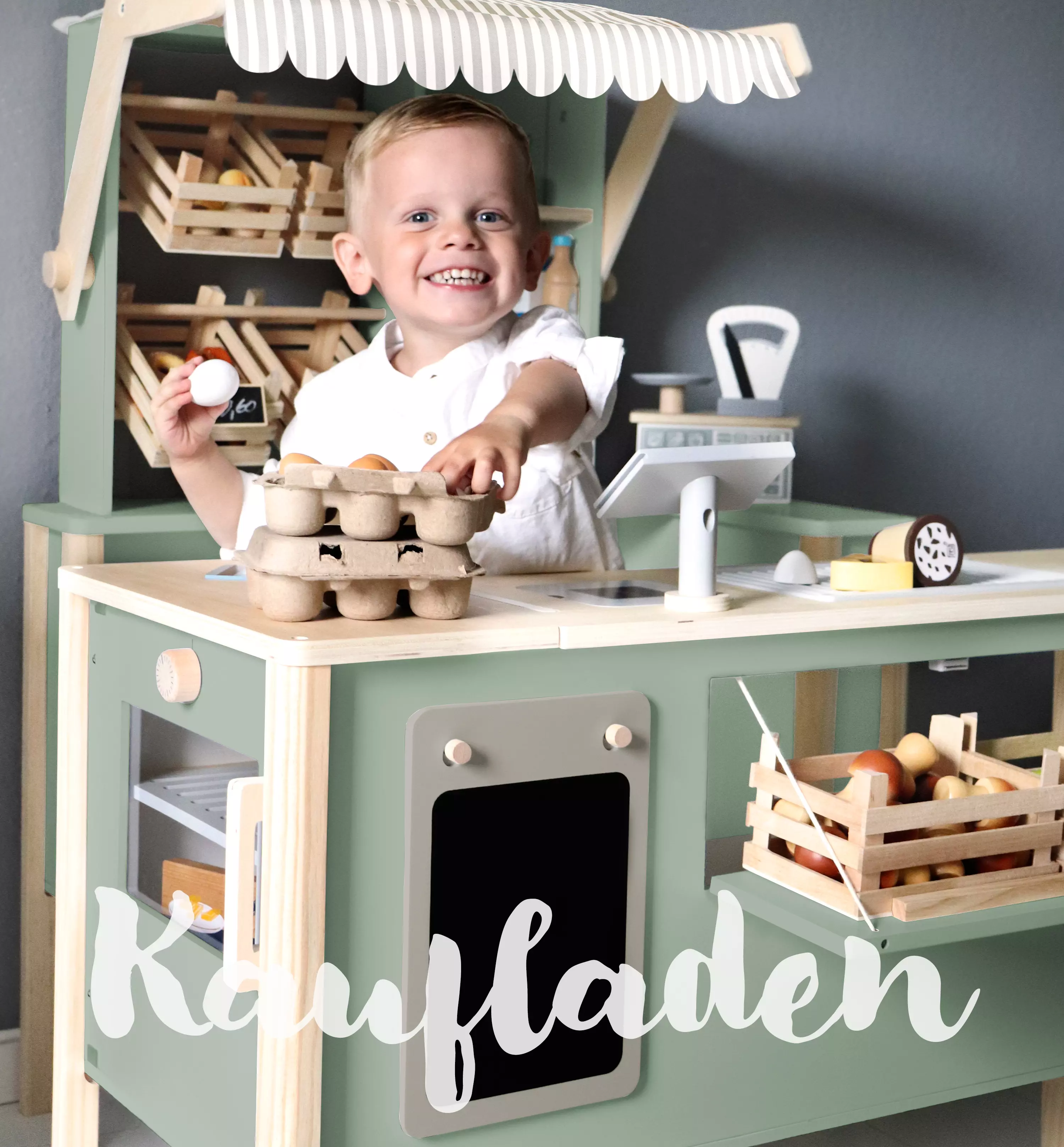 Junge spielt mit einem Kaufmannsladen aus Holz