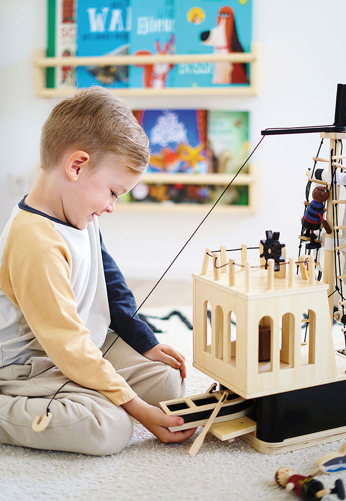 Kind spielt am Piratenschiff Holzboot