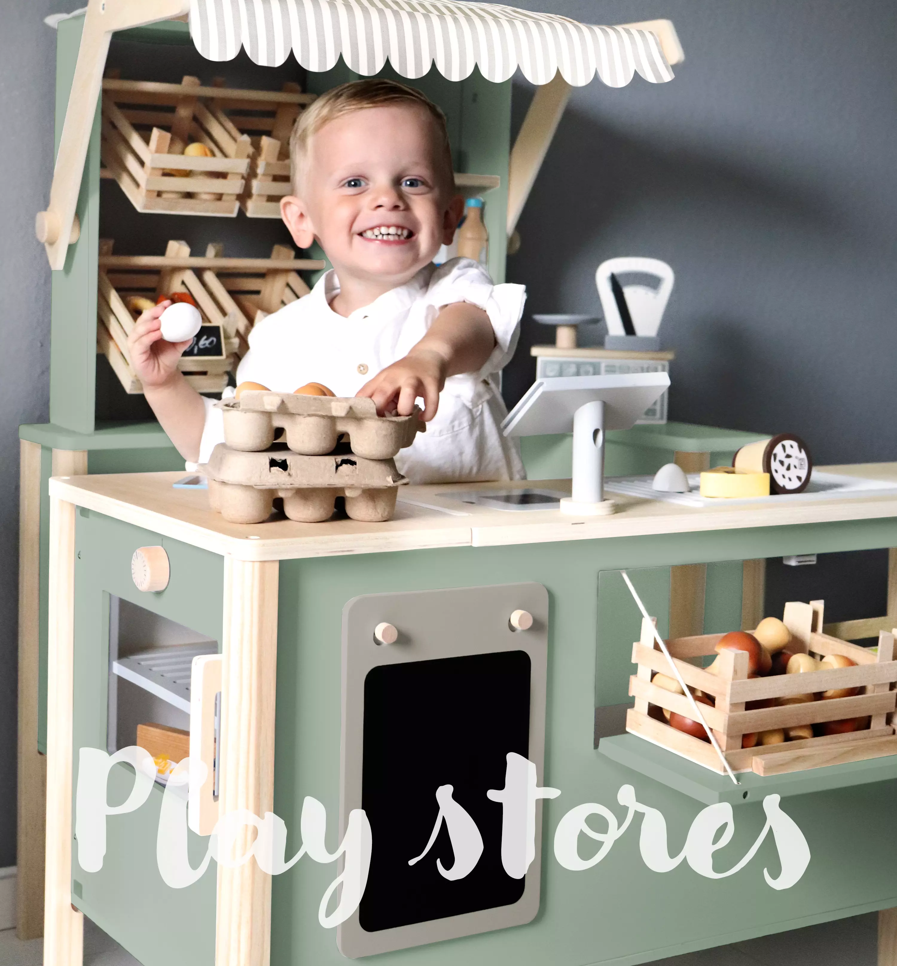 Junge spielt mit einem Kaufmannsladen aus Holz