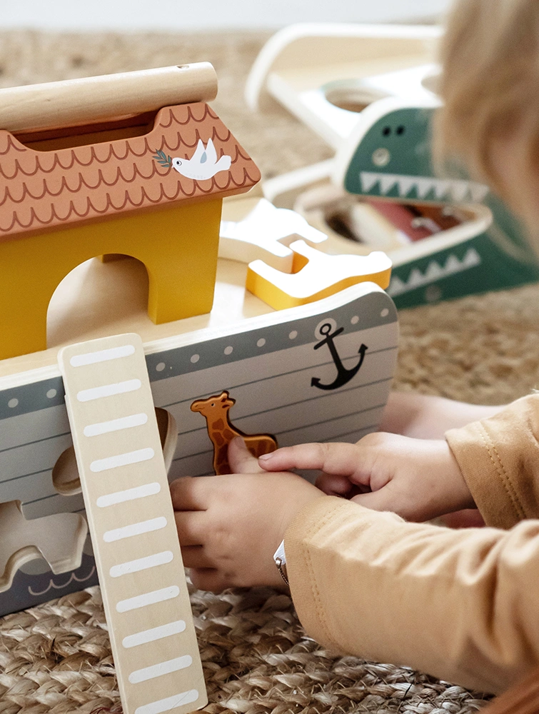 Kind spielt mit Arche Noah aus Holz