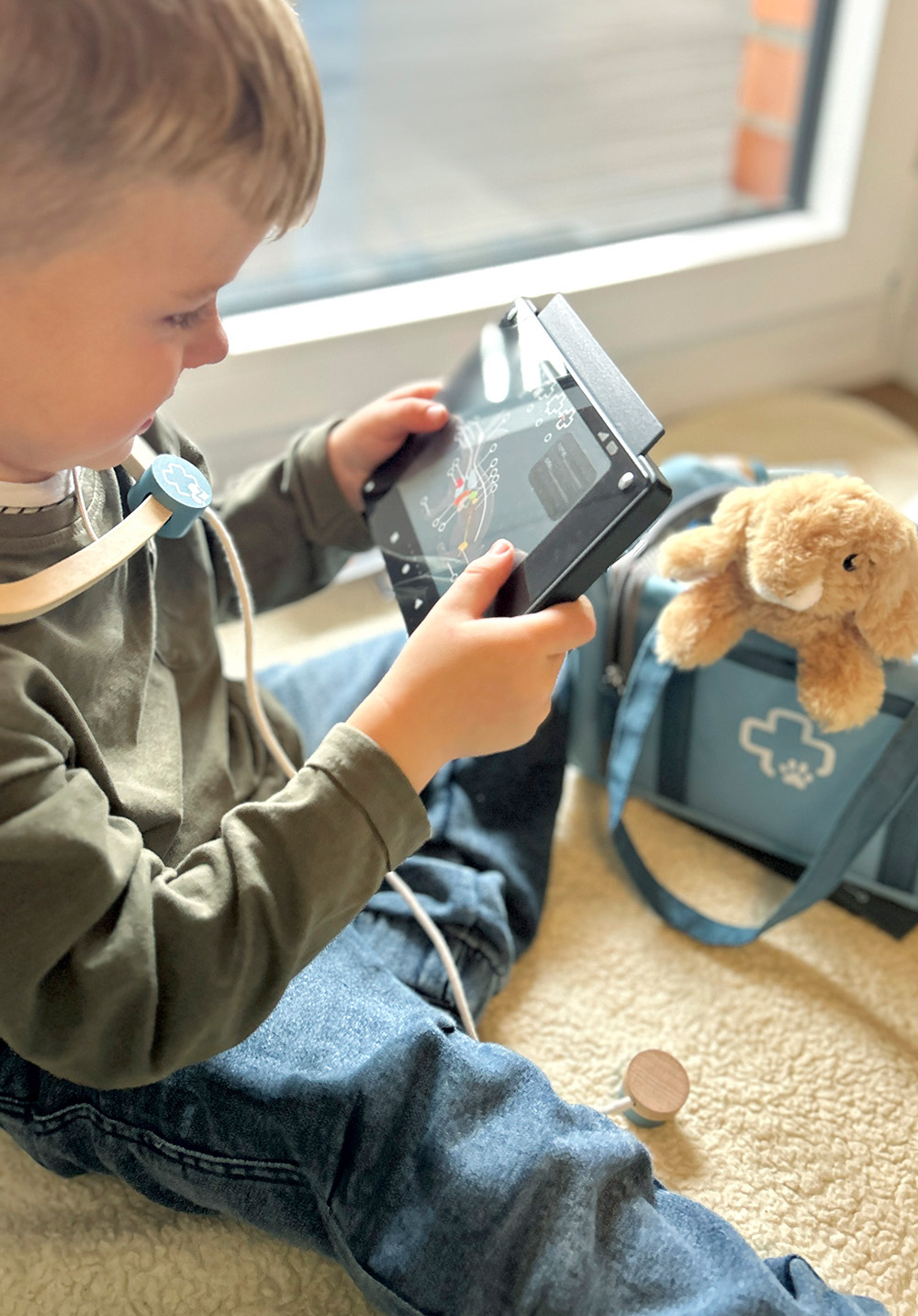 Kind spielt mit Tierarzt-Tasche mit Hase