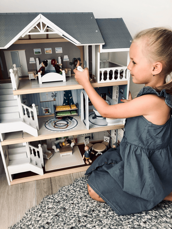Mädchen mit modernem Holz-Puppenhaus