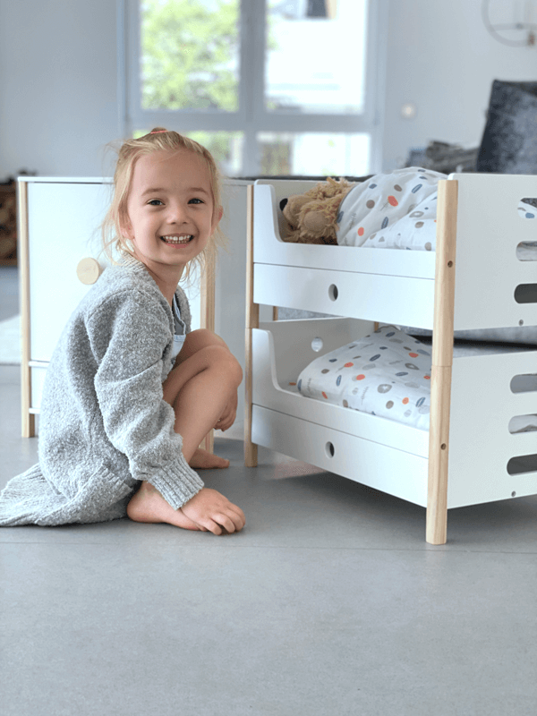 Mädchen mit Puppenhochbett aus Holz zum Spielen