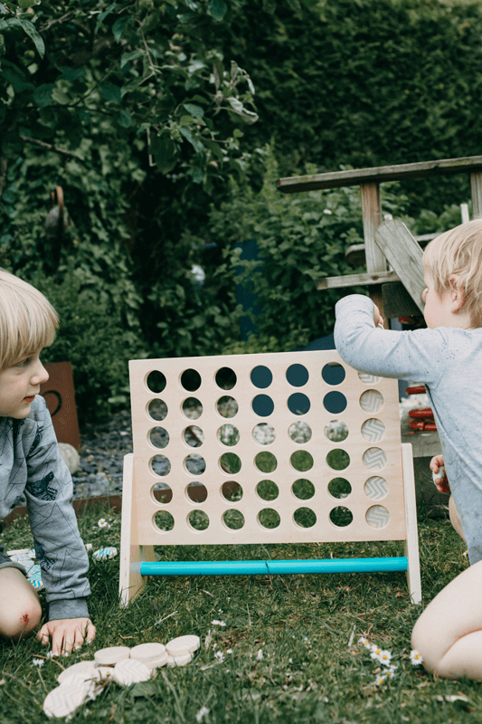 Zwei Kinder mit Vier in einer Reihe-Spiel im Garten