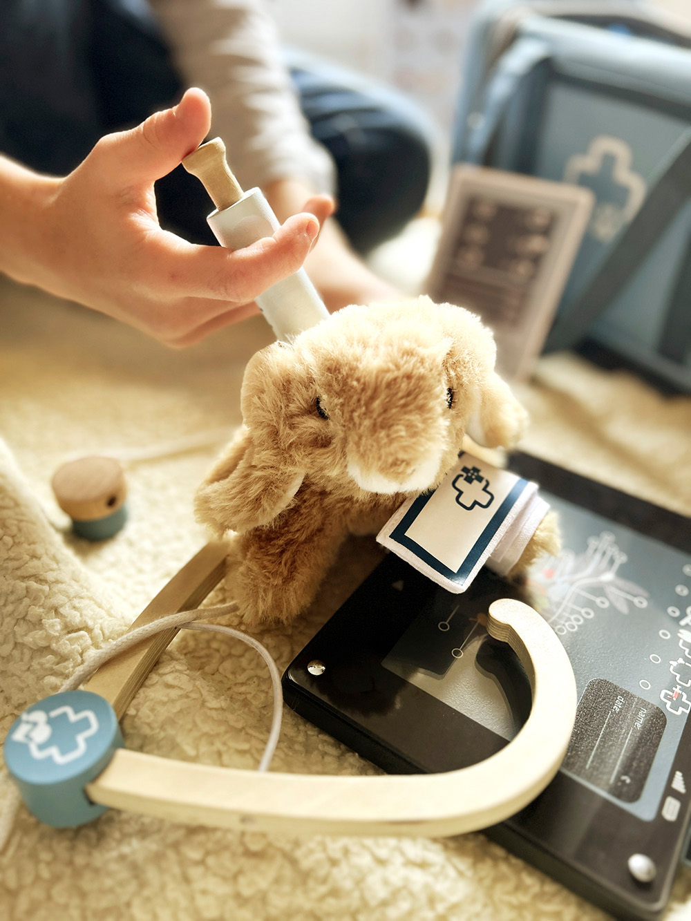 Kind spielt mit Tierarzt-Tasche mit Hase