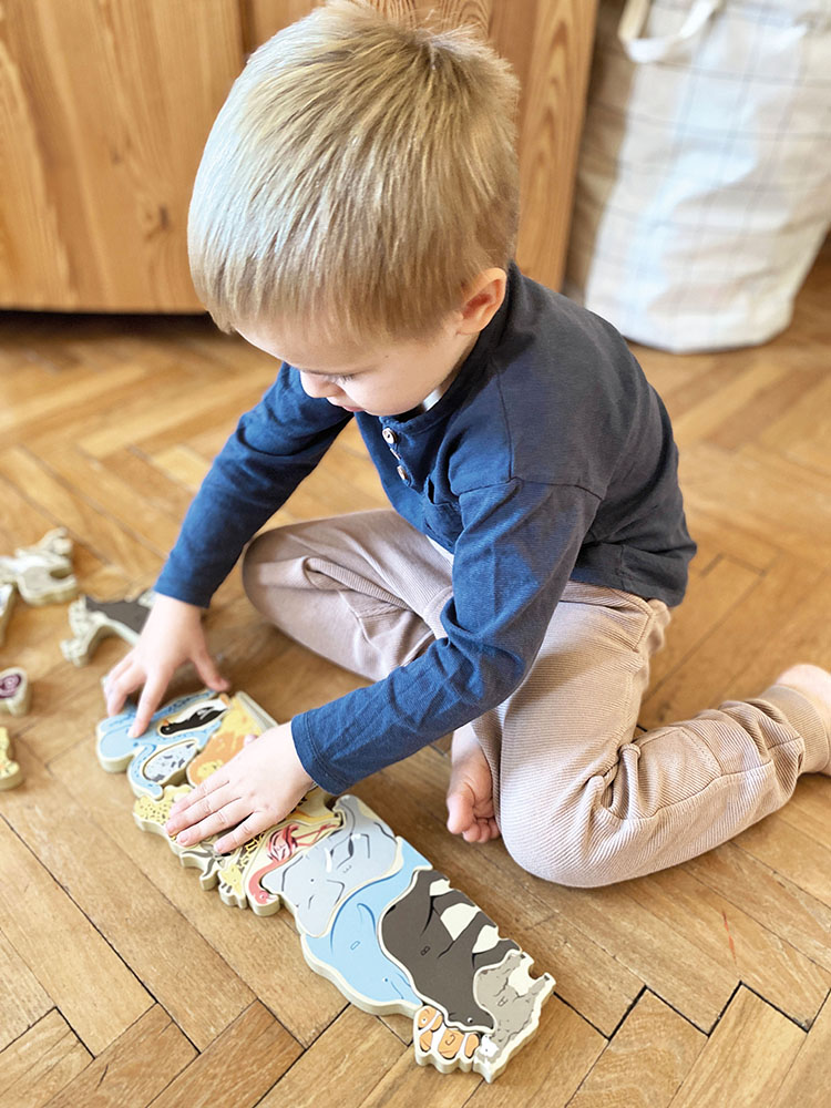 Kind spielt mit Buchstabenpuzzle Tiere