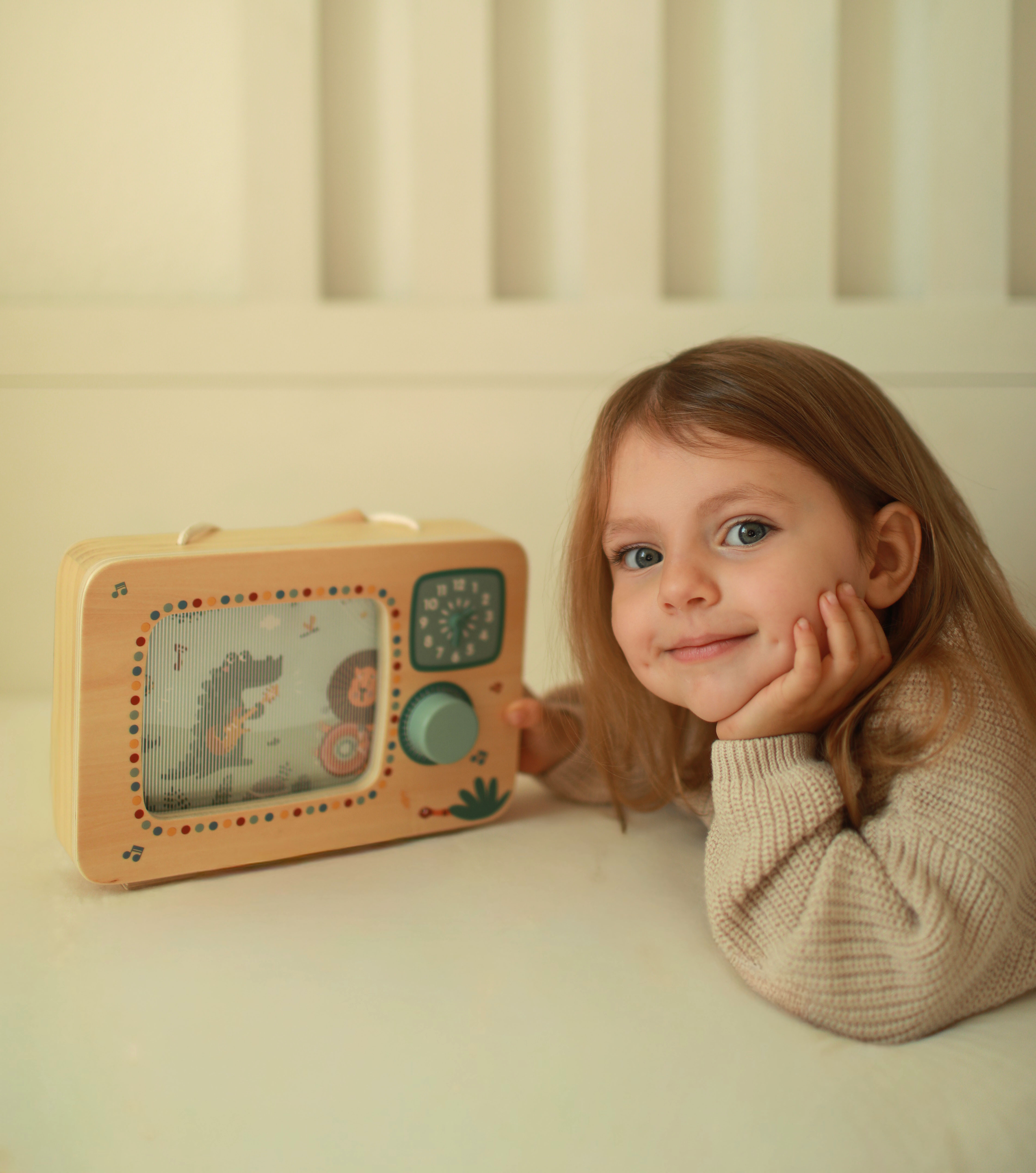 Kind spielt mit Spieluhr Fernseher Safari