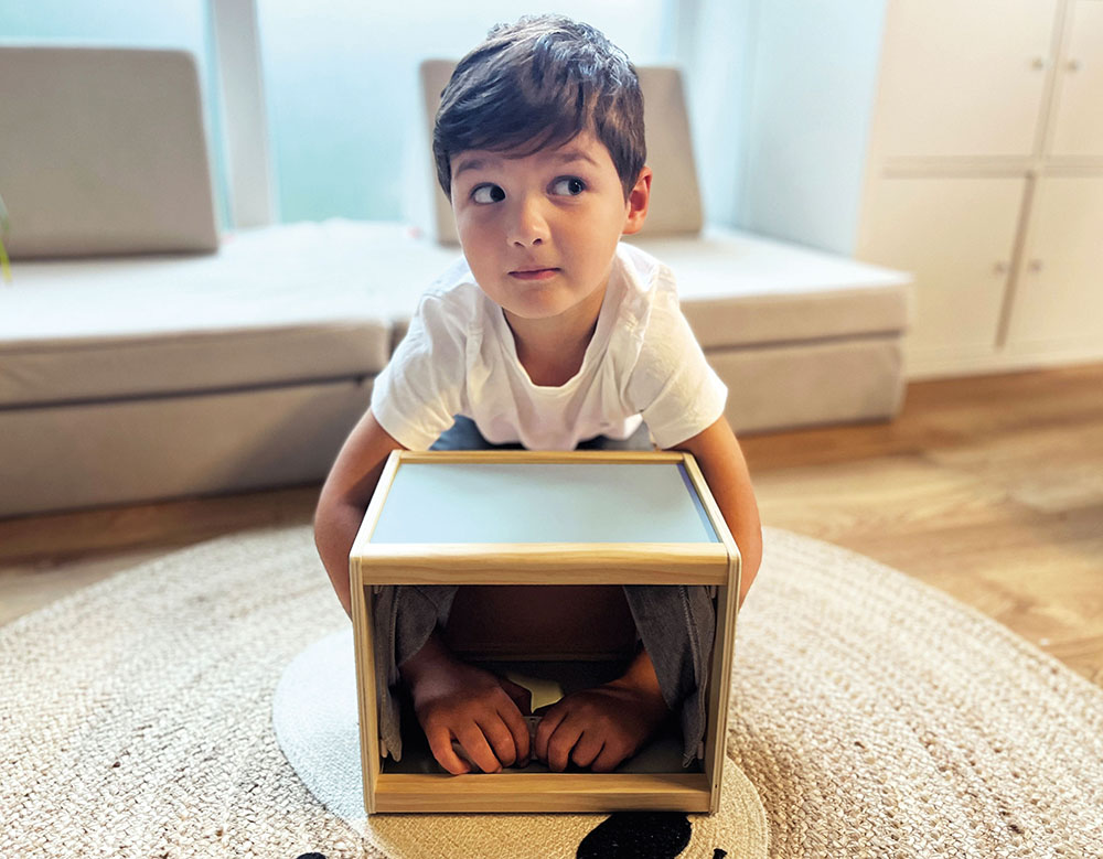 Kind erkundet die Fühlbox „Sensory“
