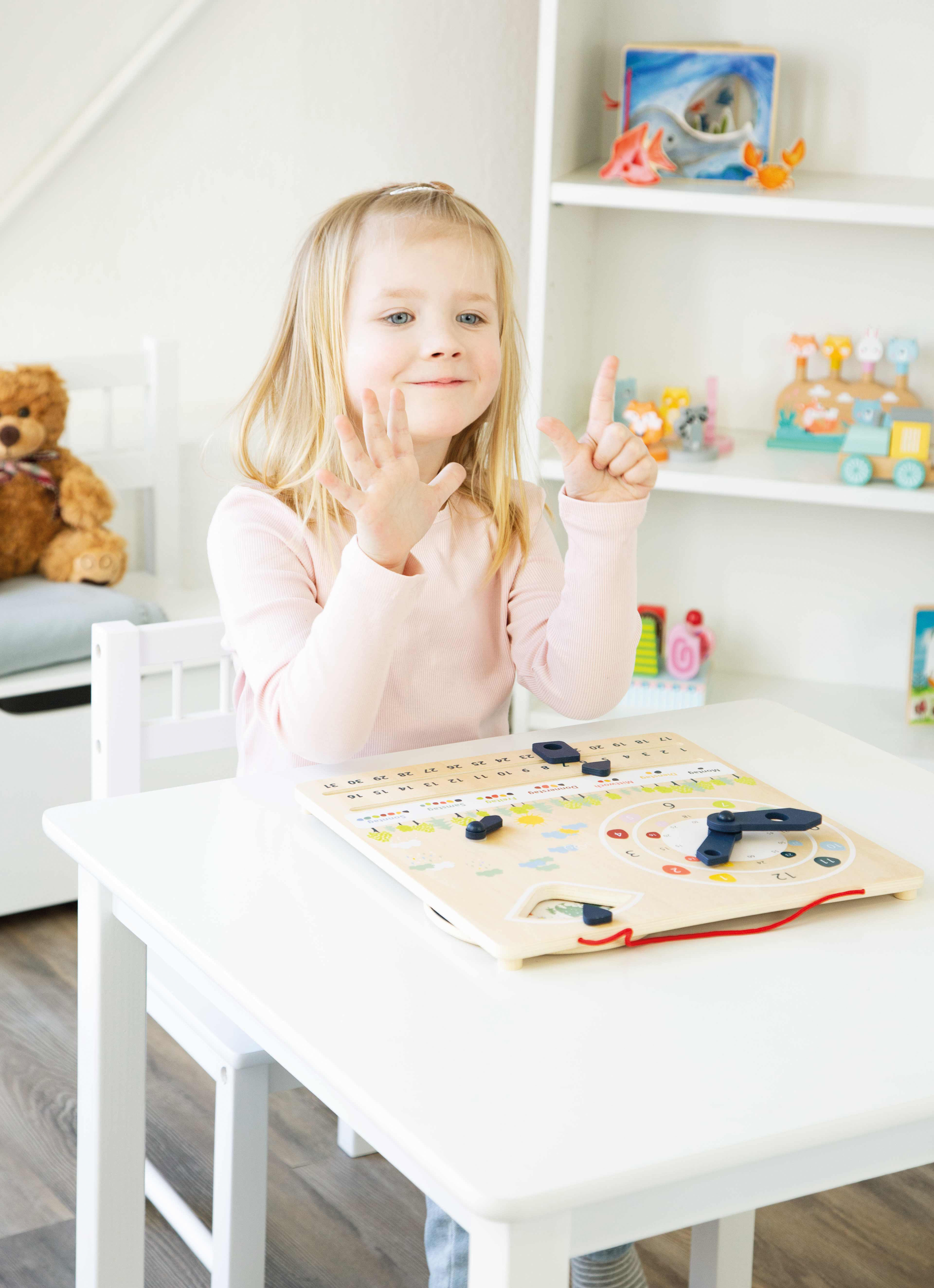 Mädchen, das vor Lerntafel steht und Uhrzeit ändert