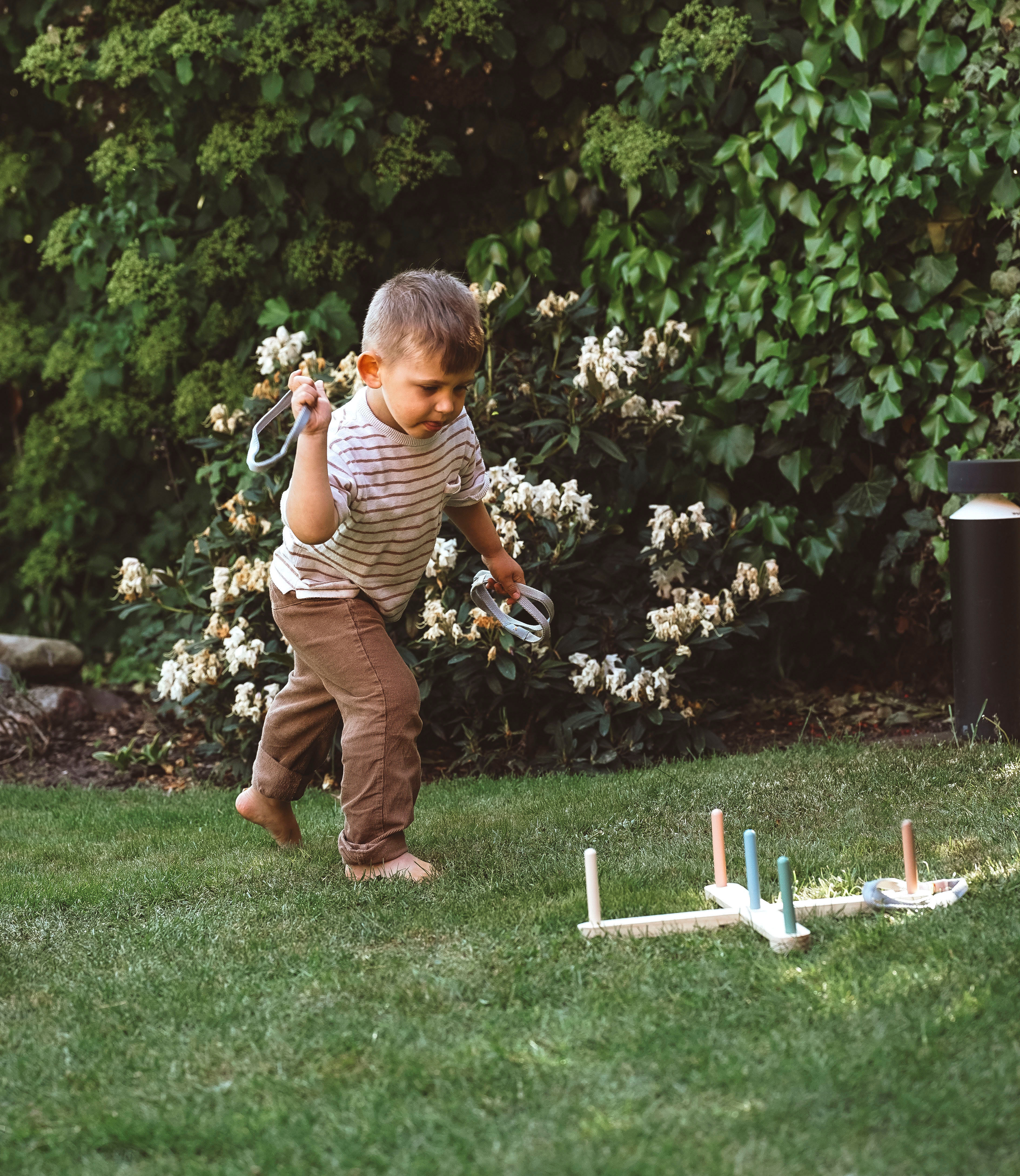 Kind spielt mit Ringwurfspiel Garden Buddies