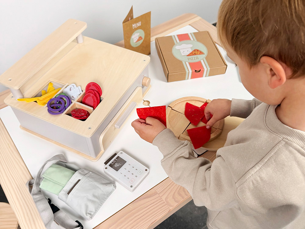 Kind spielt mit Pizza Set mit Ofen