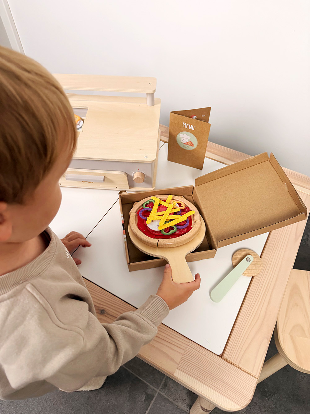 Kind spielt mit Pizza Set mit Ofen