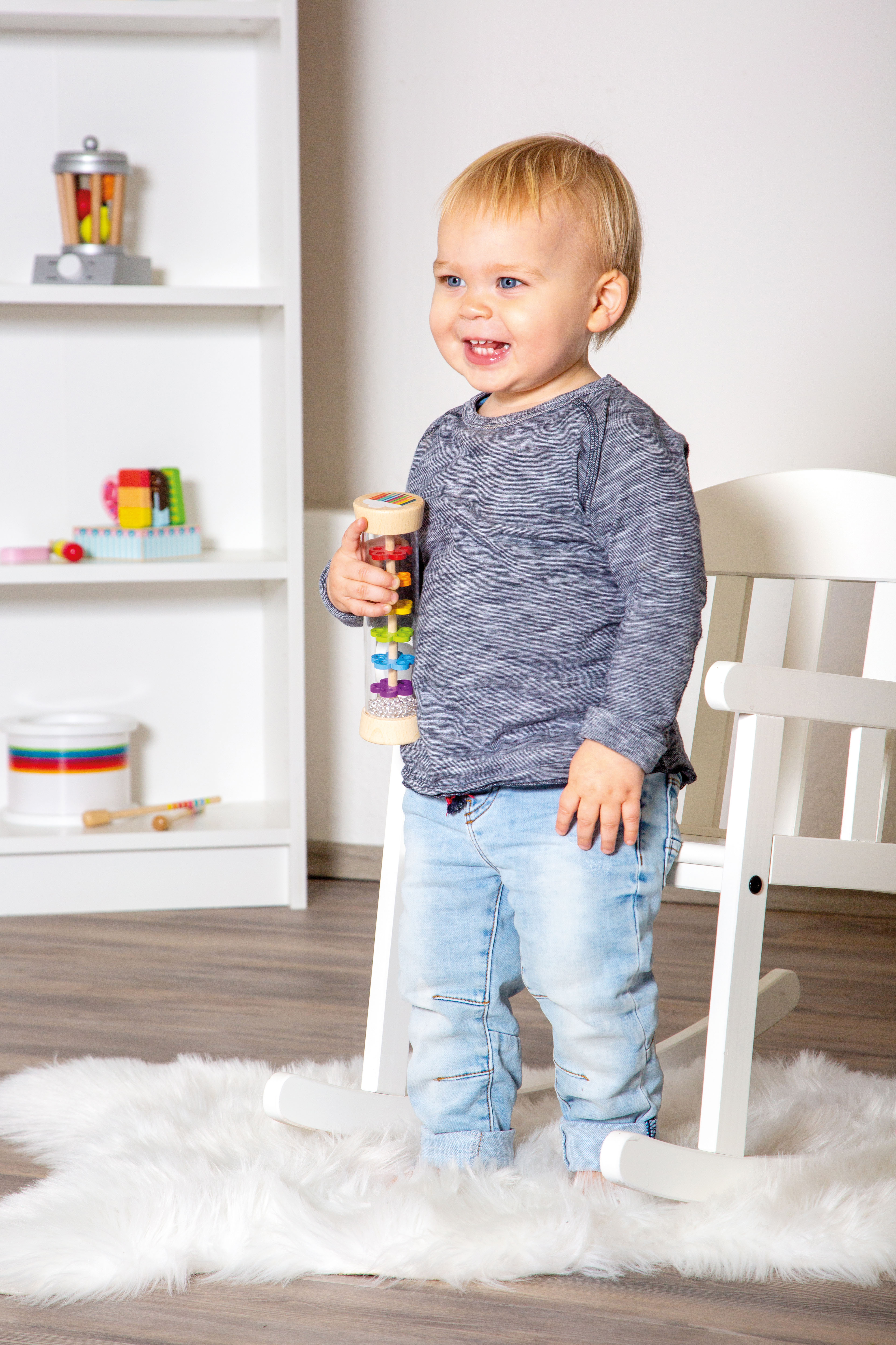 Kind spielt erfreut mit dem Regenmacher