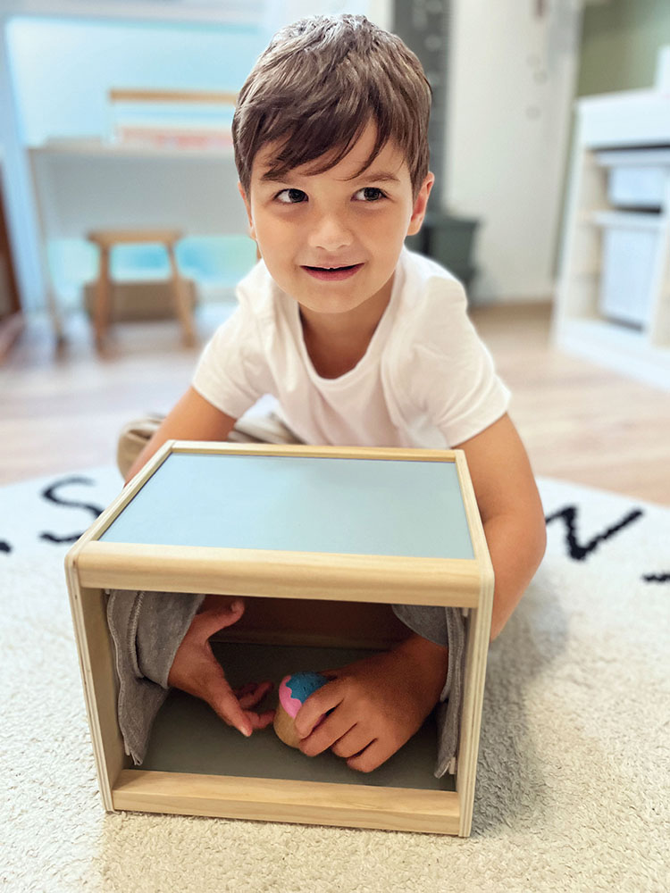 Kind erkundet die Fühlbox „Sensory“